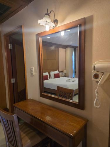 a bathroom with a mirror and a table and a bed at Mike Beach Resort in Pattaya