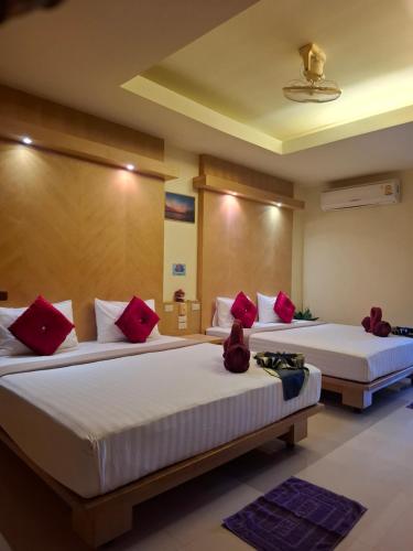 zwei Betten in einem Hotelzimmer mit roten Kissen in der Unterkunft Lanta Summer House 1 in Ko Lanta