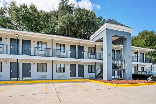 an apartment building with a car parked in a parking lot at Econo Lodge Biloxi Beach in Biloxi