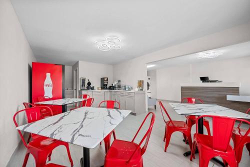 een eetkamer met rode stoelen en tafels en een keuken bij Econo Lodge Biloxi Beach in Biloxi