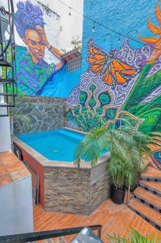 a pool in front of a wall with a mural at Cozy & Fully Equipped Studio in Zona Romantica in Puerto Vallarta
