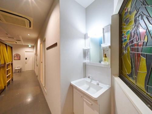 Un baño con un lavabo y un cuadro en la pared. en RetroSpect Stay Yokohama - Vacation STAY 99014v, en Yokohama