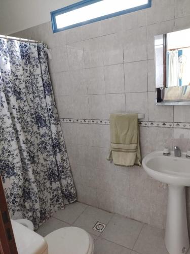 a bathroom with a shower curtain and a sink at La Calma in Los Reartes