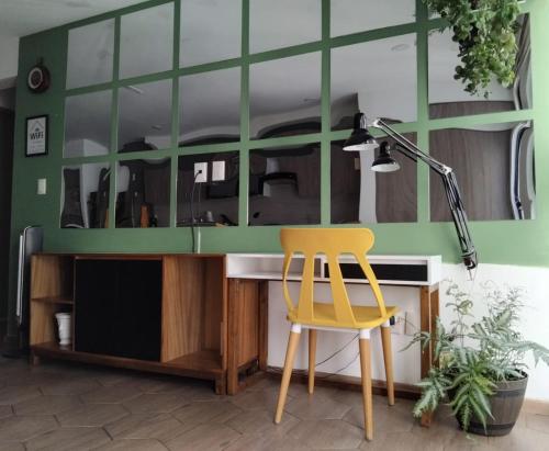a yellow chair sitting next to a desk with a mirror at CENTRAL APARTMENT IN THE HEART OF MEXICO CITY in Mexico City