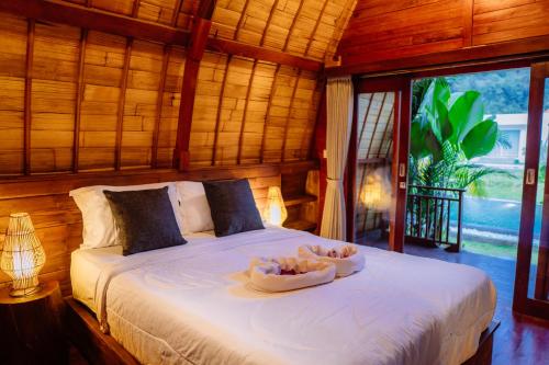 a bedroom with a bed with two bowls on it at The Caldera Villas in Kubupenlokan