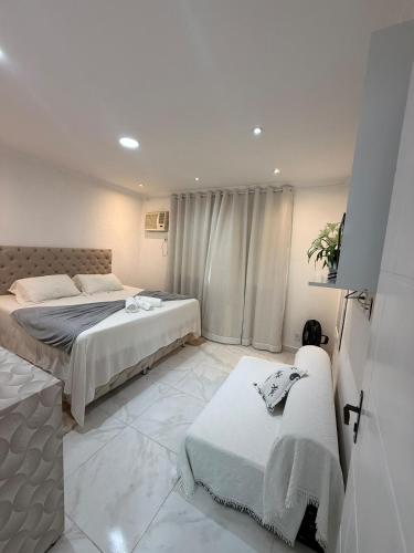 a bedroom with two beds and a couch in it at Casa independente em tuncuns in Búzios