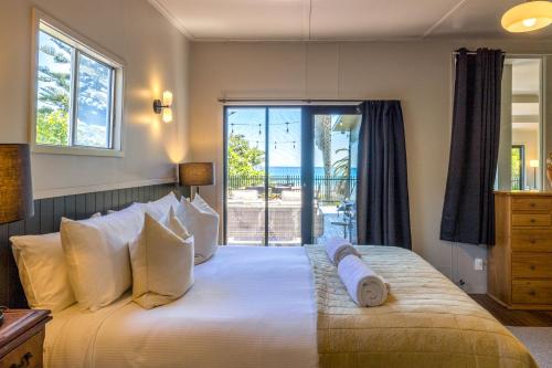 een slaapkamer met een groot bed met uitzicht op de oceaan bij Moana Beach House - Absolute beachfront in Onetangi in Waiheke Island