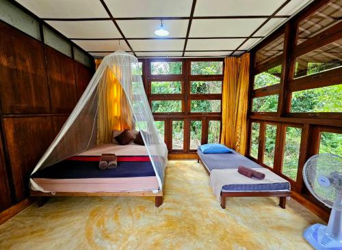 阁帕延岛Phayam Valley Homestay的带床和蚊帐的卧室