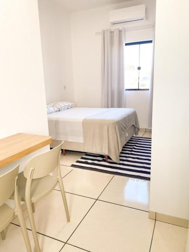 a bedroom with a bed and a table and chairs at Ap8 - Aconchegante e Completo com Ótimo Custo-Benefício in Guaíra