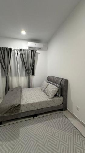 a bed sitting in a room with a curtain at 9 Beradik Homestay in Kajang