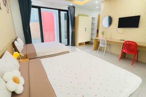Una habitación con una cama y un escritorio con televisión. en Homestay phòng gần biển, TTTP - 1988 homestay, en Vung Tau