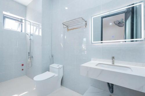 Un baño blanco con lavabo e inodoro. en Homestay phòng gần biển, TTTP - 1988 homestay, en Vung Tau