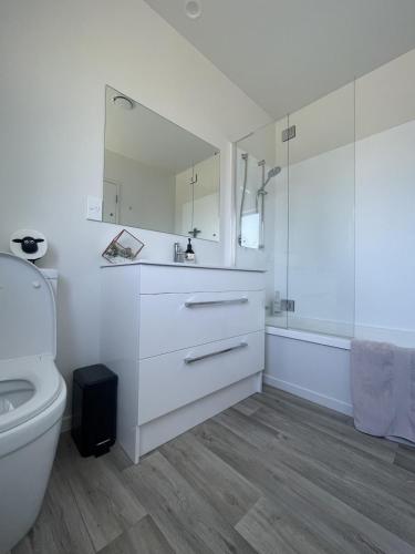a white bathroom with a sink and a toilet at Playground Fun on Town Doorstep! in Ohakune