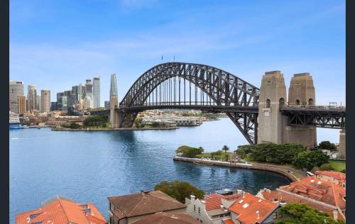 a bridge over a river with a city at Stunning Harbour Bridge Views Apartment in Sydney
