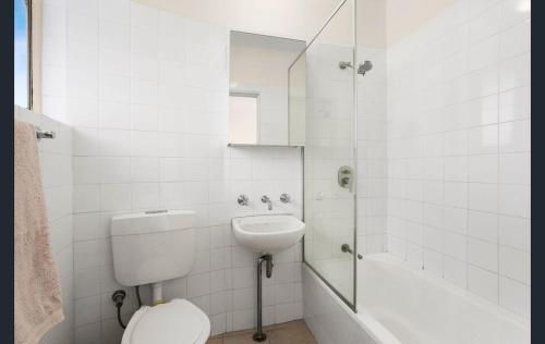 a bathroom with a toilet and a sink and a shower at Stunning Harbour Bridge Views Apartment in Sydney