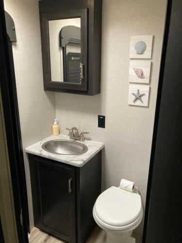 a bathroom with a sink and a toilet and a mirror at RV by the Sea in North Topsail Beach