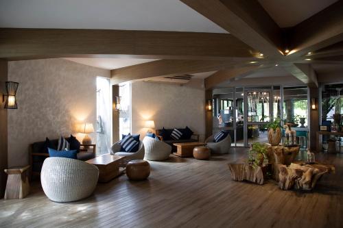 Una gran sala de estar con sofás y mesas. en The Leela Resort & Spa Pattaya, en Pattaya central