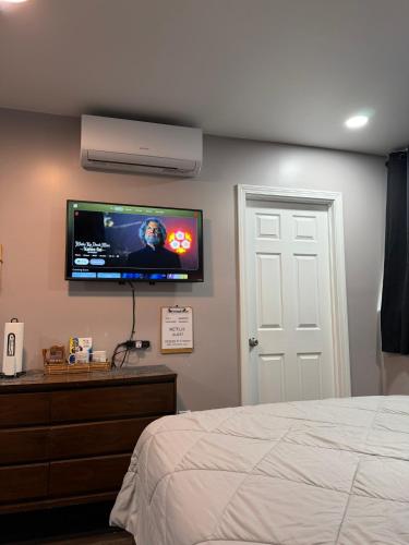 a bedroom with a flat screen tv on the wall at Basement room with its own private bathroom in Providence