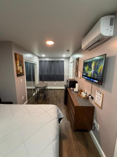 a bedroom with a bed and a living room at Basement room with its own private bathroom in Providence
