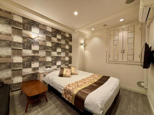 a bedroom with a bed and a desk with a chair at Hotel PRINCESS2 -大人専用- in Tokyo