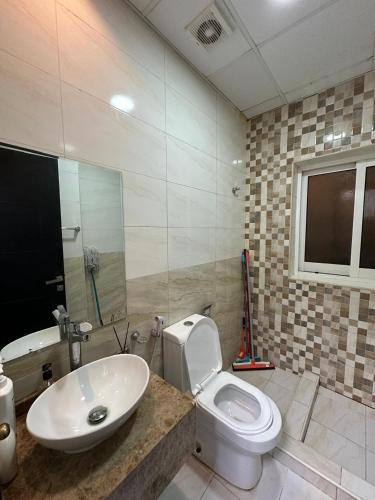 a bathroom with a white toilet and a sink at Entire Studio Apartment Beside Oasis towers in Ajman