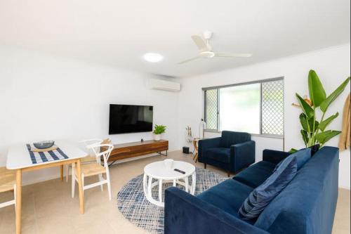 a living room with a blue couch and a table at 2-Bedroom Charm near Mater Hospital Pimlico Townsville in Aitkenvale