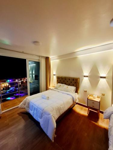 a bedroom with a large bed and a large window at HOTEL MAR Y LAGO in Lunahuaná