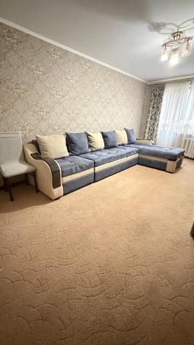 un gran sofá azul en la sala de estar en 2х комнатная квартира на Толе би, en Taraz