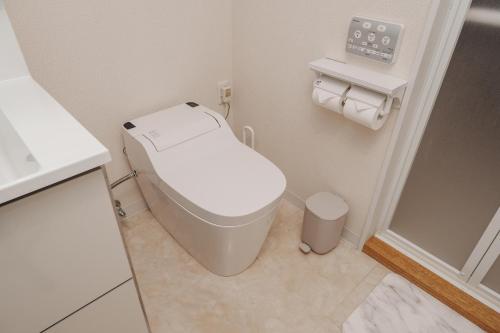 um pequeno banheiro com um vaso sanitário e uma pia em Sunstone Residence 2F - Free Rental Car included! em Ginowan