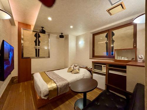 a hotel room with a bed and a television at Hotel Crystal -大人専用-- in Tokyo
