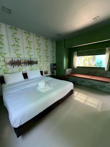 a bedroom with a large white bed and a window at ยูสีเกด รีสอร์ท in Si Sa Ket