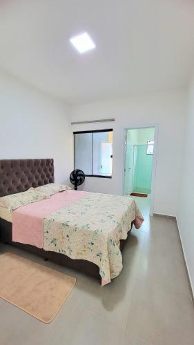 ein Schlafzimmer mit einem Bett und einem Fenster in der Unterkunft Jenni's House in Itapoa