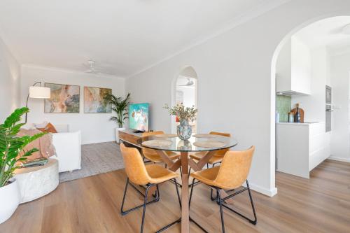 a dining room and living room with a table and chairs at Spacious Apartment Near Cronulla Beach in Cronulla