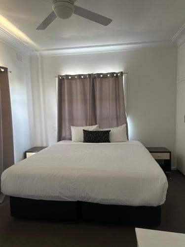 a bedroom with a large white bed with a ceiling at 80 Tarcutta St in Wagga Wagga