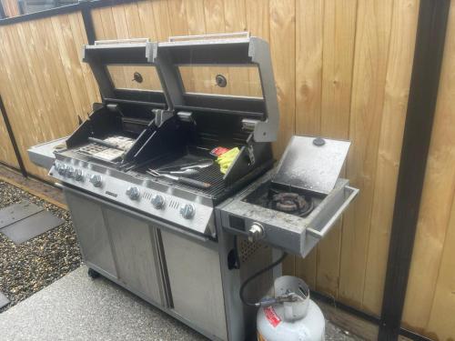 una parrilla de barbacoa junto a una valla de madera en Modern Ensuite Room with Light Kitchenette & Private Entrance in Cromwell, en Cromwell