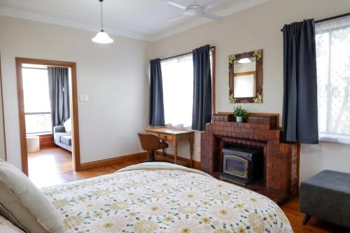 Schlafzimmer mit einem Bett, einem Kamin und einem Spiegel in der Unterkunft Spacious 3-Bed Home in Central Tenterfield in Tenterfield