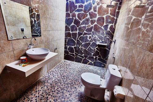 łazienka z toaletą i umywalką w obiekcie Matra Bali Guesthouse w mieście Canggu