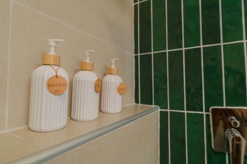 three white bottles sitting on a shelf in a bathroom at Baansiwalin in Phra Nakhon Si Ayutthaya