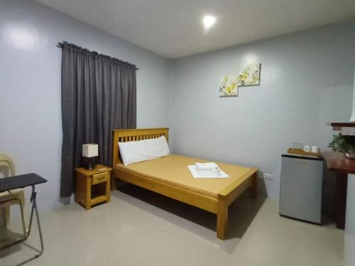 ein kleines Zimmer mit einem Bett und einem Fenster in der Unterkunft Grae’s Apartelle in Moalboal