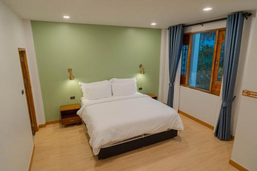 a bedroom with a bed with white sheets and pillows at Baansiwalin in Phra Nakhon Si Ayutthaya