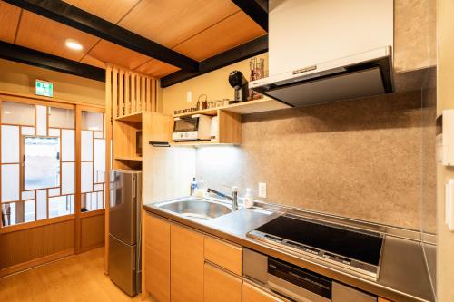 une cuisine avec un évier et une cuisinière dans l'établissement Machiya Izumi higashiyama, à Kyoto