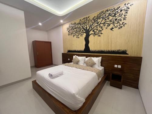 een slaapkamer met een bed met een muurschildering van bomen aan de muur bij Honeymoon Villa canggu in Sempidi