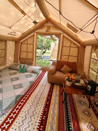 a living room of a tent with a couch and a table at Lhong Luk Khao Camping in Ban Khlong Kathon