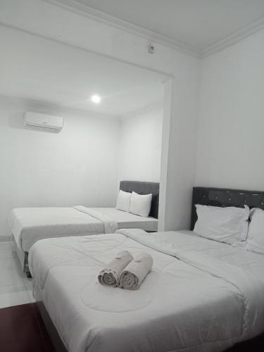 two beds in a room with towels on them at Pakemsari Resort Hotel in Pakem
