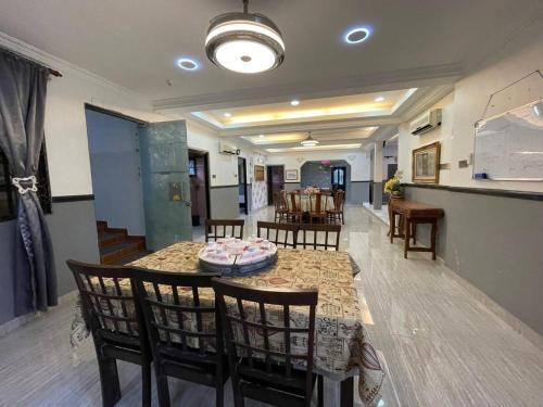 ein Esszimmer mit Tisch und Stühlen und eine Küche in der Unterkunft Idid homestay in Kota Belud