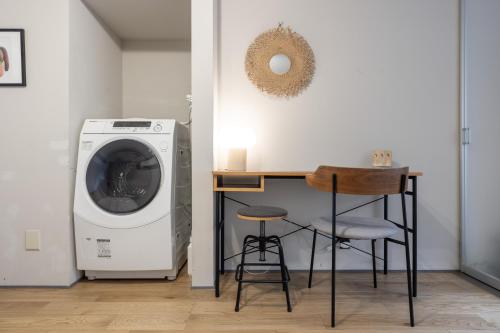 a laundry room with a washing machine and a stool at SAKON UKON in Kanazawa