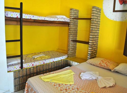 two bunk beds in a room with yellow walls at Pousada Espaço Litoral in Baixio