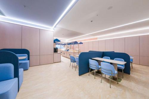 a conference room with blue chairs and a table at Hanting Hotel Shanghai Pudong Airport Shixin Road in Shanghai