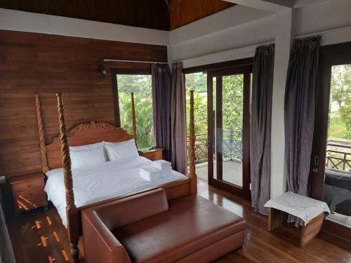 a bedroom with a bed and a couch and windows at Thao’s Villa in Ho Chi Minh City