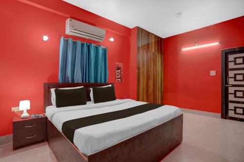 Un dormitorio con una cama grande con paredes rojas. en Super Hotel O Patliputra Railway Station Formerly Rameshwaram Guest House, en Dānāpur